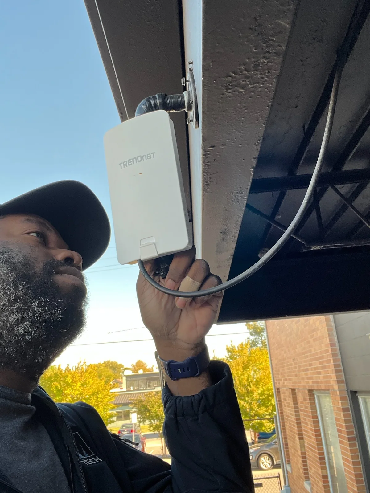 FM Tech technician installing a wireless network bridge on a commercial building.